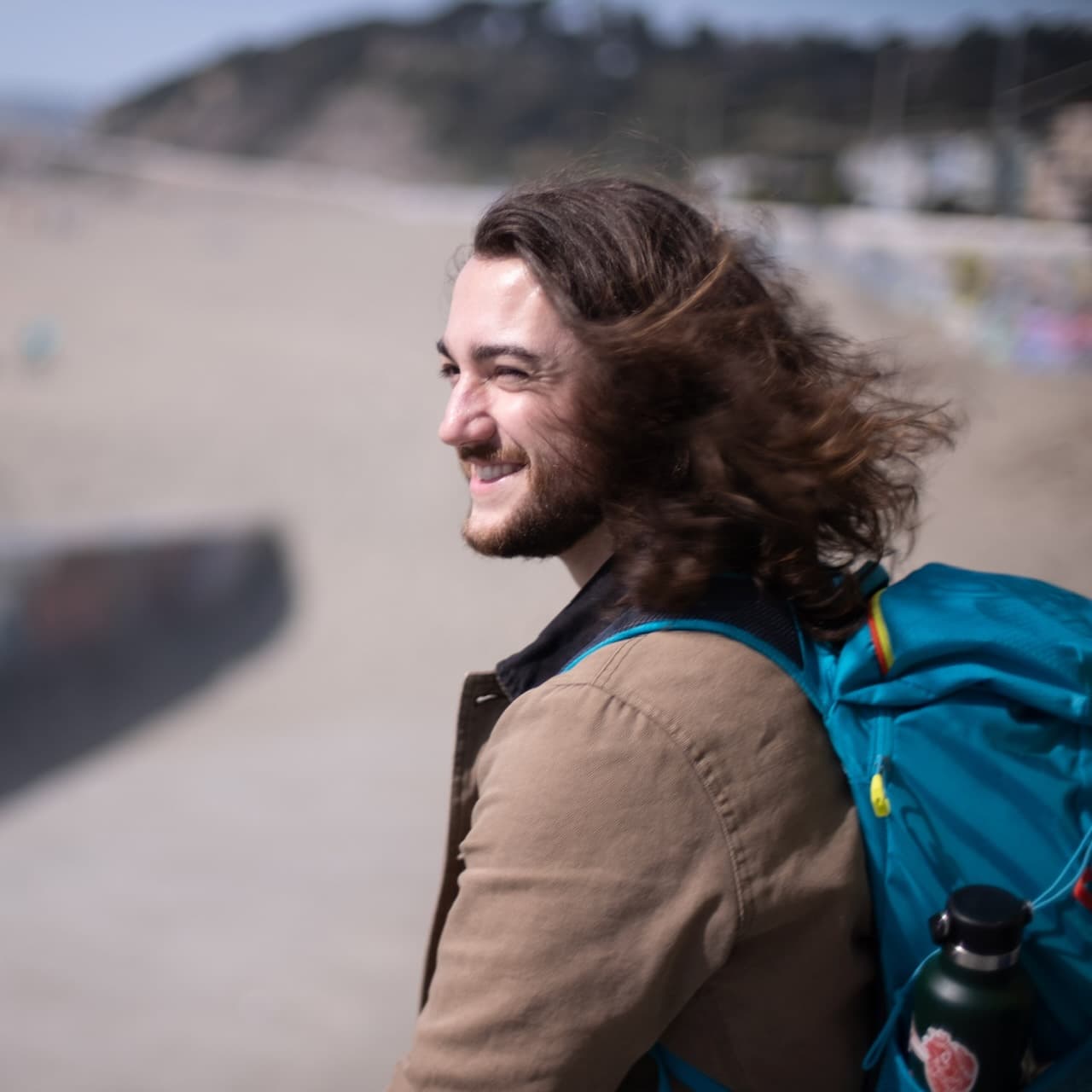 A photo of me at Ocean Beach, wearing a backpack (like software engineers do) and looking out towards the water.